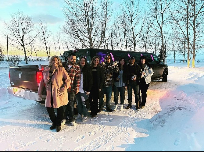 A group of friends standing in front of a limousine