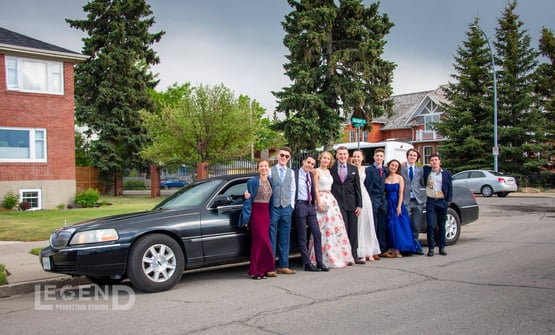 Group celebrating graduation in front of Black Lincoln Stretch Limo