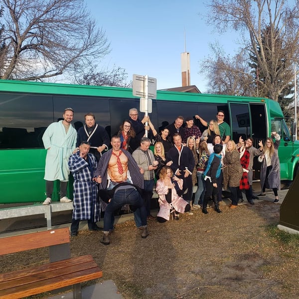 Adult pajama party in front of green Godzilla Party Bus