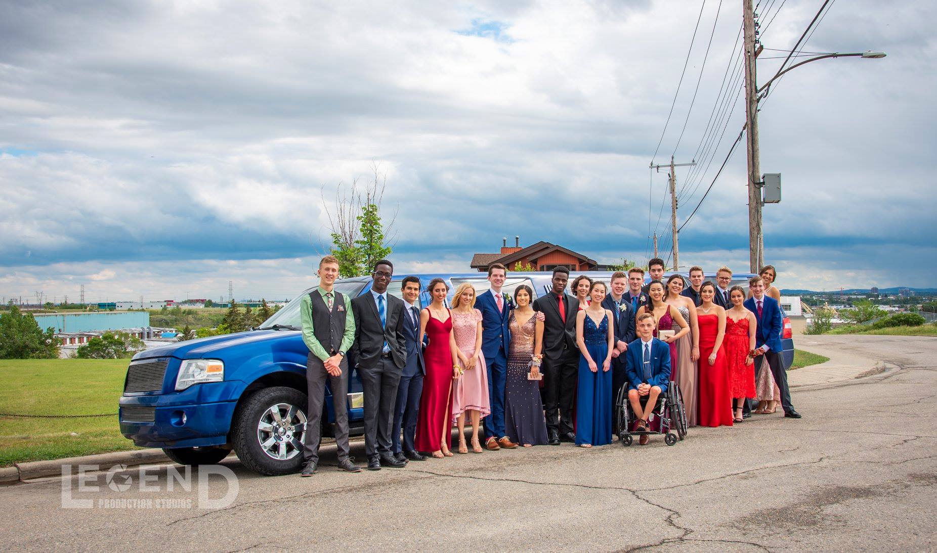 Graduation group takes photo in front of Blue Expedition Limousine