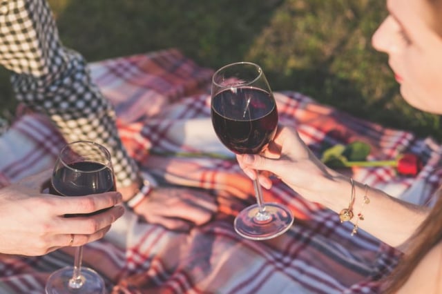 man and women enjoying drinks in a park