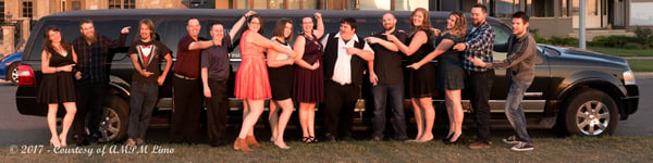 Group posing silly for photo in front of black Expedition Limousine