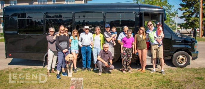 Large family photo in front of black Party Bus