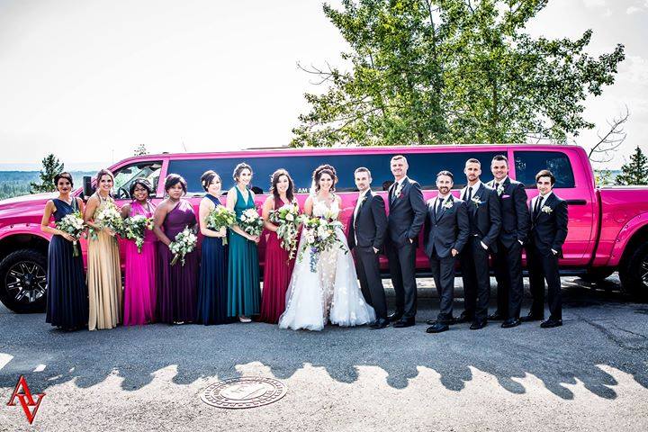 Wedding Party photo in front of Pink Dodge Ram Limo