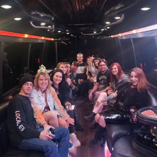 Group posing for photo inside of party bus