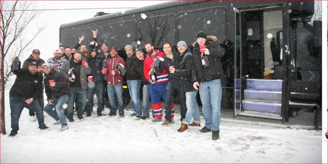 Group of guys celebrating stag party with black party bus
