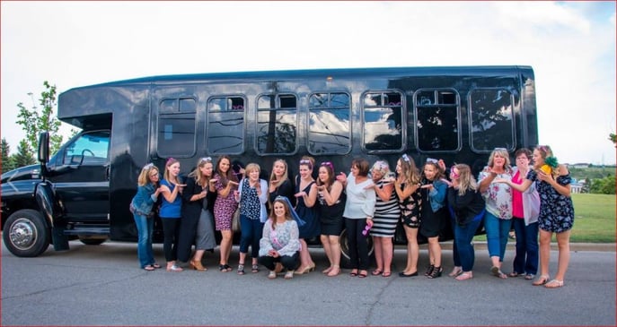 Bachelorette party photo in front of black Party Bus
