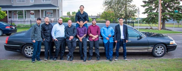 Group of 9 guys celebrate Stag with photo in front of a black Lincoln Stretch Limousine