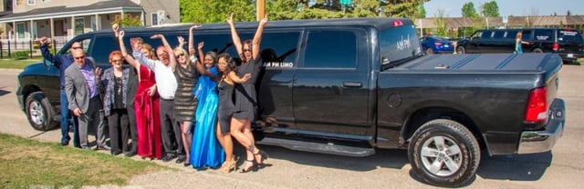 Group celebrating in front of black Dodge Ram Limo