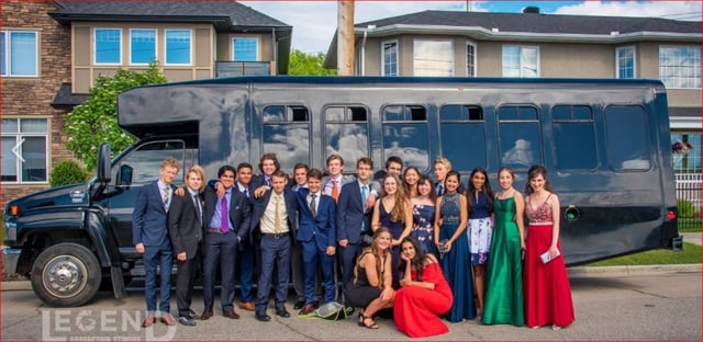 Graduation group photo in front of a black Party Bus in Alberta