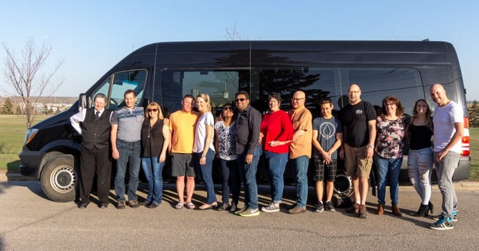 Group photo in front of black Mini Mercedes Party Bus