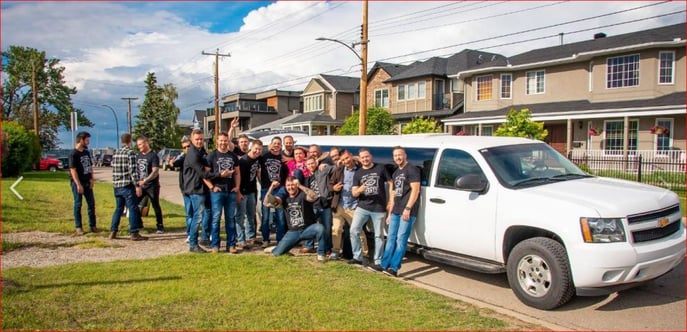 Group of guys posing for photo with white Suburban Limousine