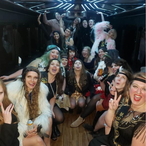 Group dressed in costumes celebration photo taken inside of a party bus
