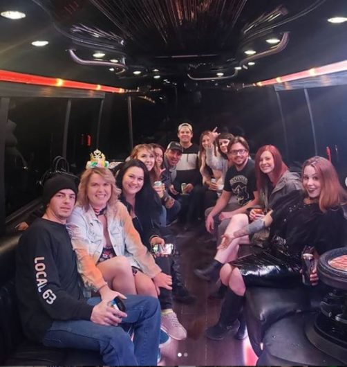 Group of adults inside of a party bus celebrating