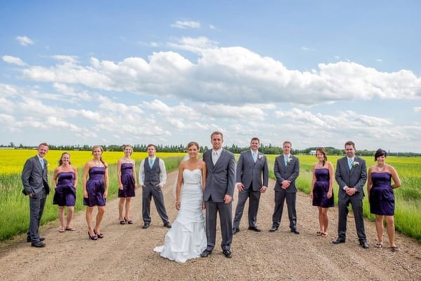 Bride and groom photo with wedding party in field in Alberta