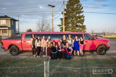 Group of ladies standing in front of pink Dodge Ram Limo