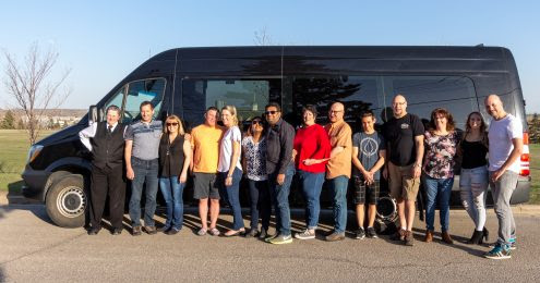 group photo in front of black mini Mercedes Party Bus
