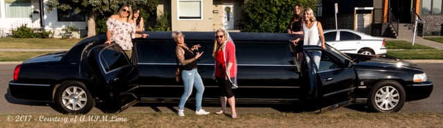 Ladies standing up in all 4 doors of black Lincoln Stretch Limo