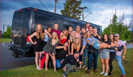 Group photo in front of black Party Bus