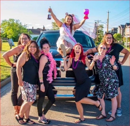 Stagette celebration photo in front of Dodge Ram Limo with bride to be sitting on the hood