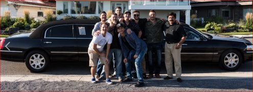 Group of guys posing for photo in front of black Lincoln Stretch Limousine