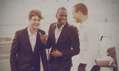 3 men laughing outside of vehicle