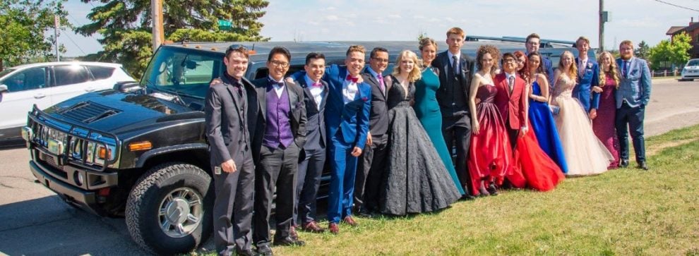 Group graduation photo with black Hummer Limo