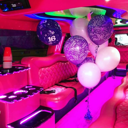 Girls birthday balloon bouquet inside of an all pink Dodge Limousine